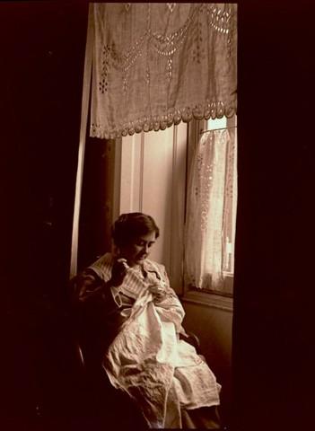 Paola Franzoni (Lina) che cuce alla finestra