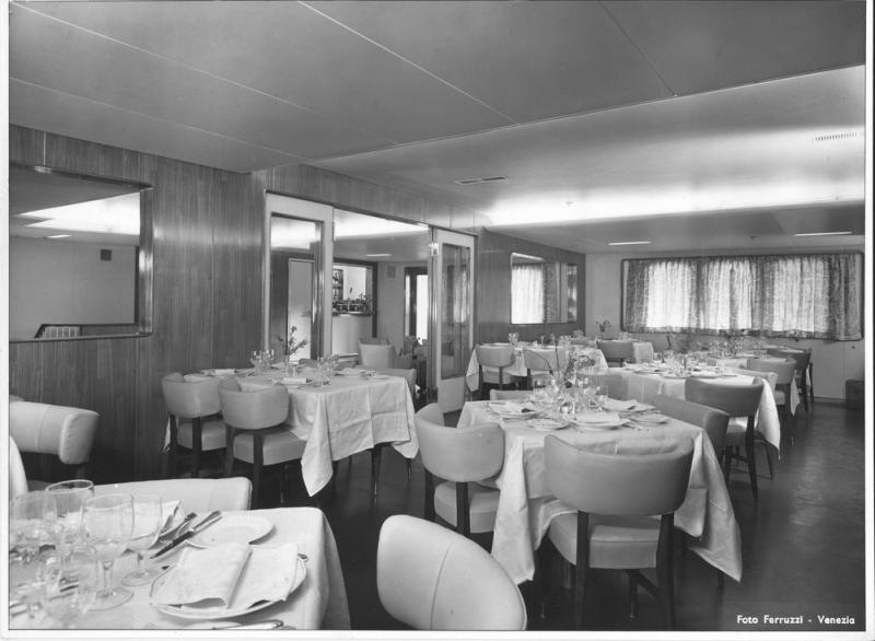Messapia - Sala da pranzo della nave Messapia con tavoli imbanditi e porta scorrevole per l' accesso alla zona Bar
